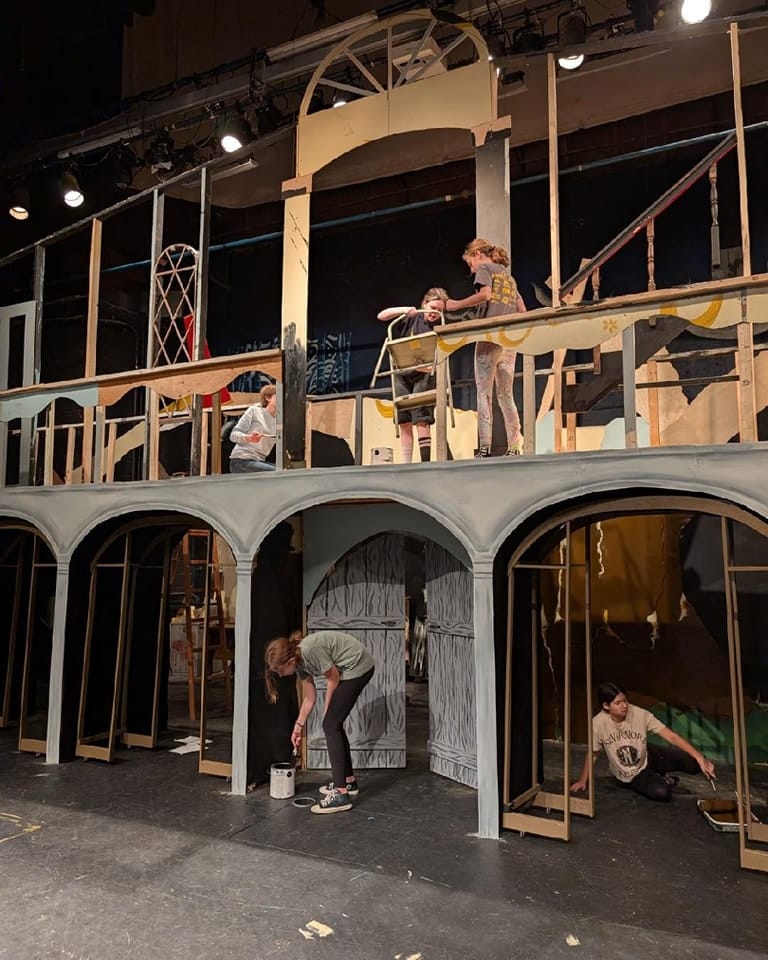 A group of students volunteering with set design for a play